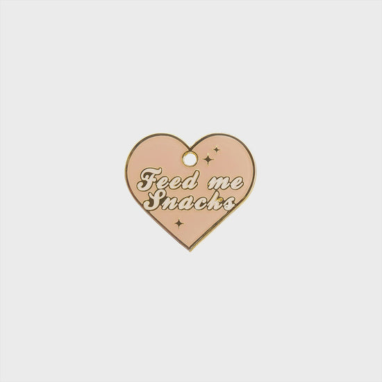 Load and play video in Gallery viewer, Feed Me Snacks Heart Tag - pink and gold enamel pet id tag says feed me snacks| trill paws
